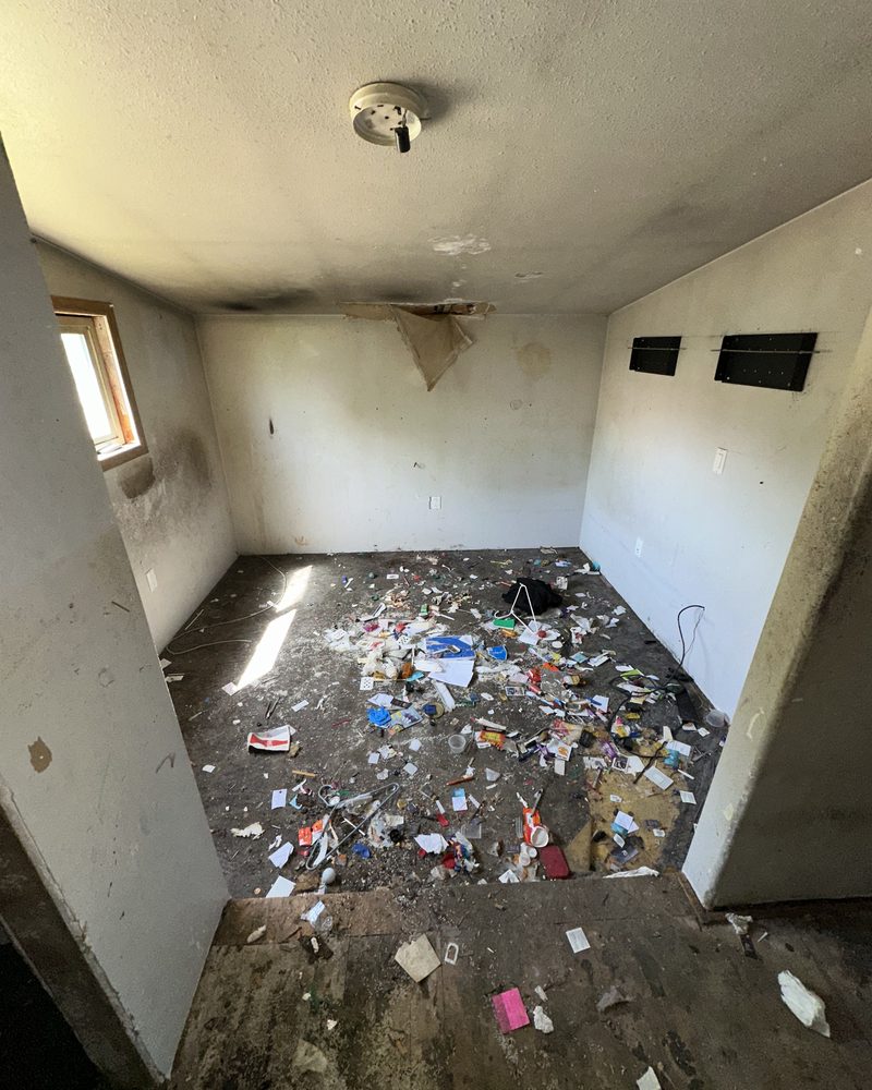 A bedroom before: smoke stains and debris